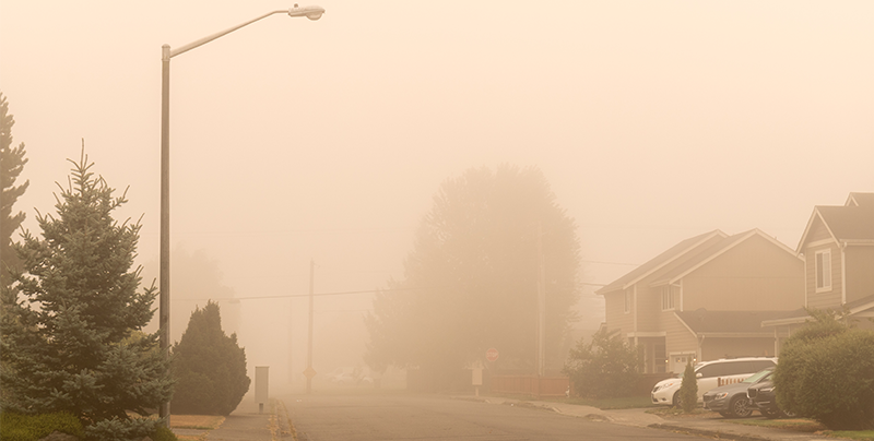 Smokey sky from a forest fire over a residential neighborhood