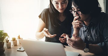 man and woman discussing options while looking at computer