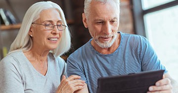 man and woman looking at tablet