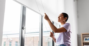 person closing window shades