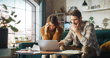 People discussing bills while looking at computer