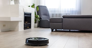 smart robotic vacuum cleaner on laminate wood floor in living room