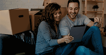 couple on computer surrounded by boxes